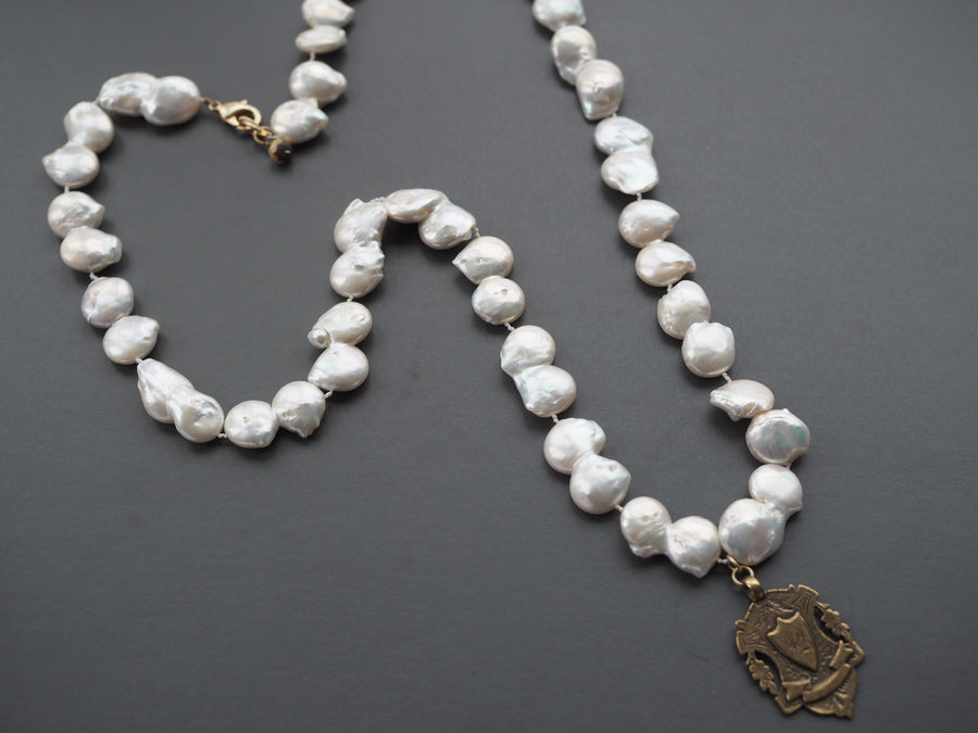 Long Baroque pearl necklace with gold charm