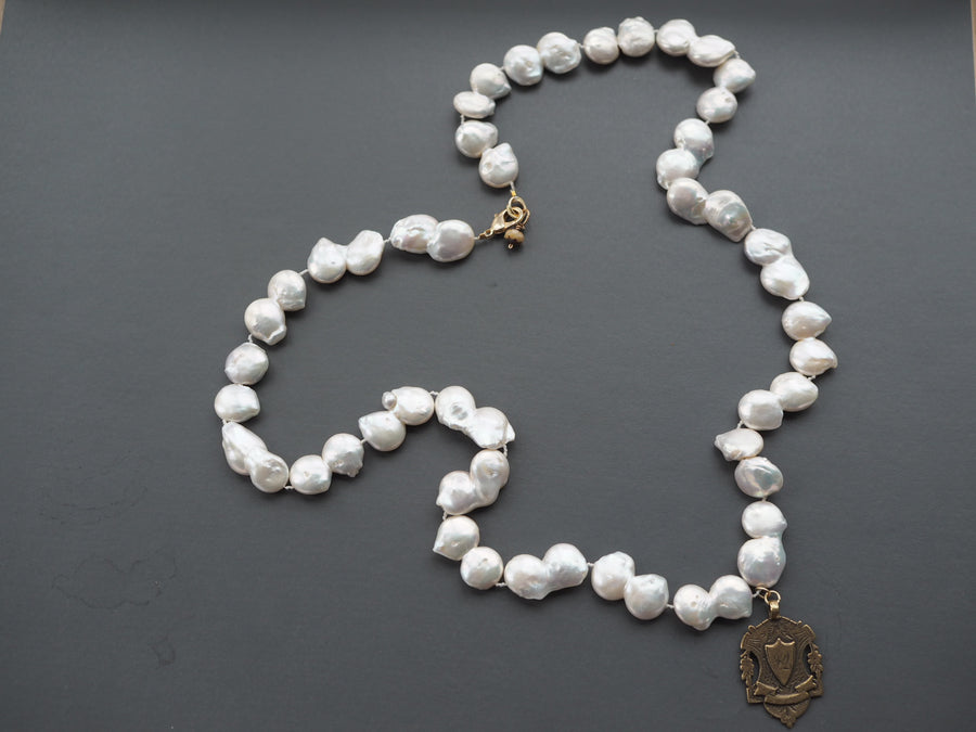 Long Baroque pearl necklace with gold charm