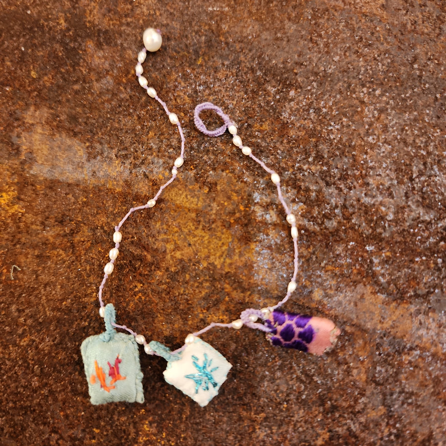Embroidered silk charm bracelet on a string of semi precious stones by Antonia Rossi