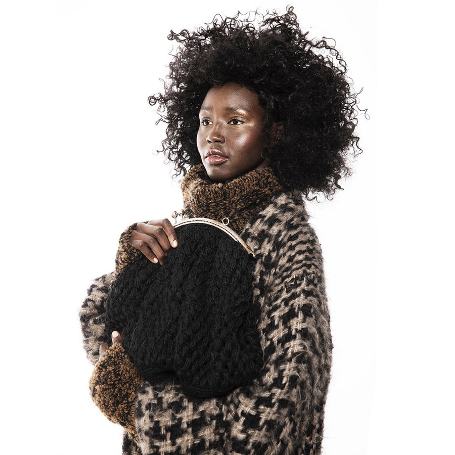 Model holding a black Hand Crochet Linen Handbag XL from Amano by Lorena Laing