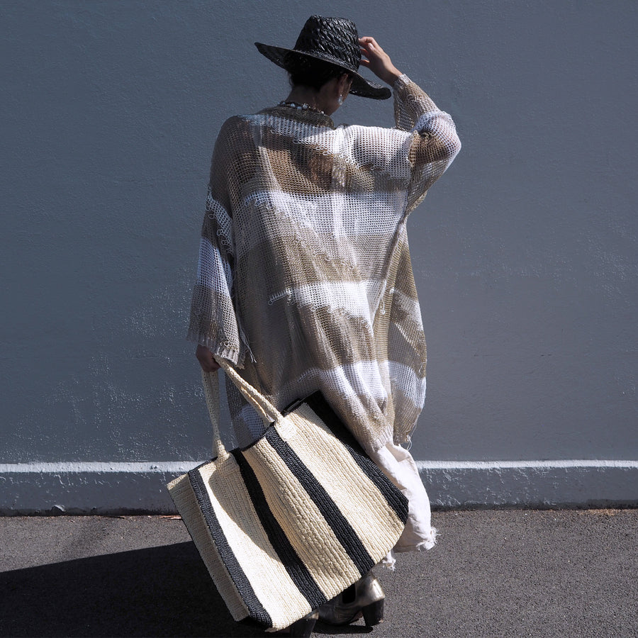 Model holding a Gabriele Frantzen White Black  Raffia Weekender Bag