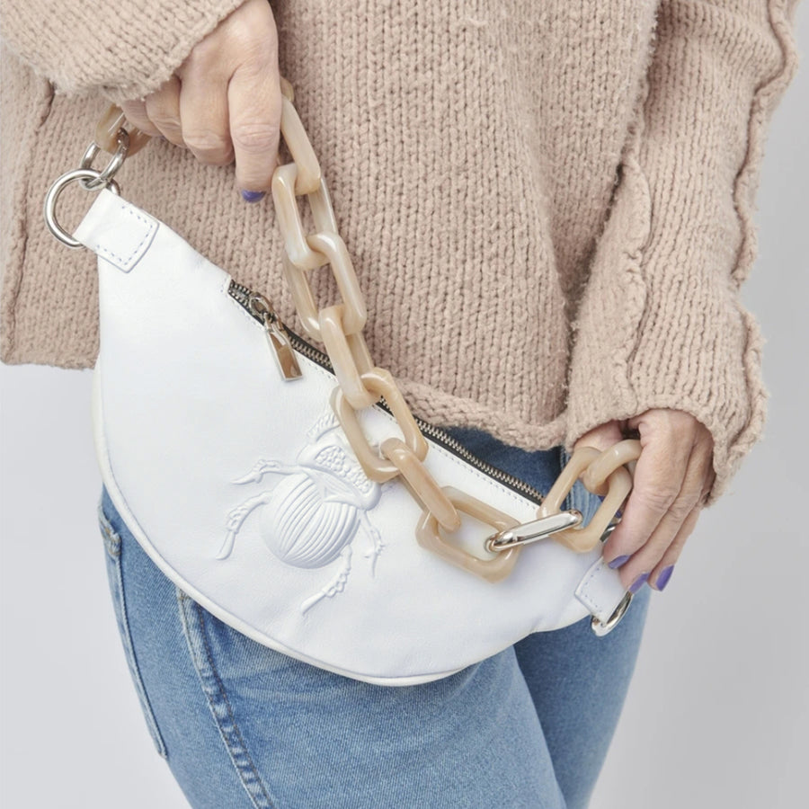Model holding a Gabriele Frantzen White Scarab Belt Bag