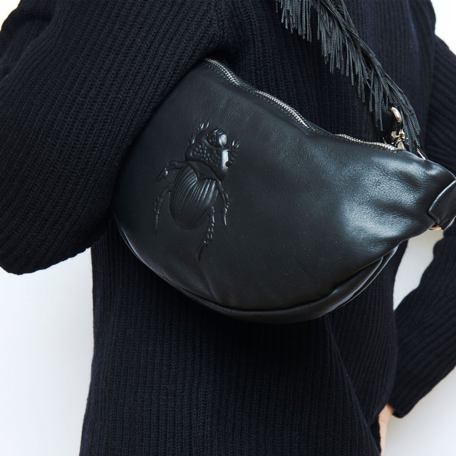 Model holding a Gabriele Frantzen Black Scarab Belt Bag
